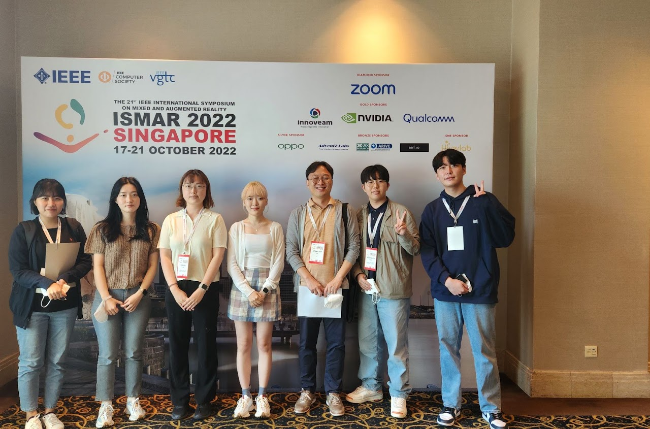 Group photo in front of the ISMAR 2022 conference display.