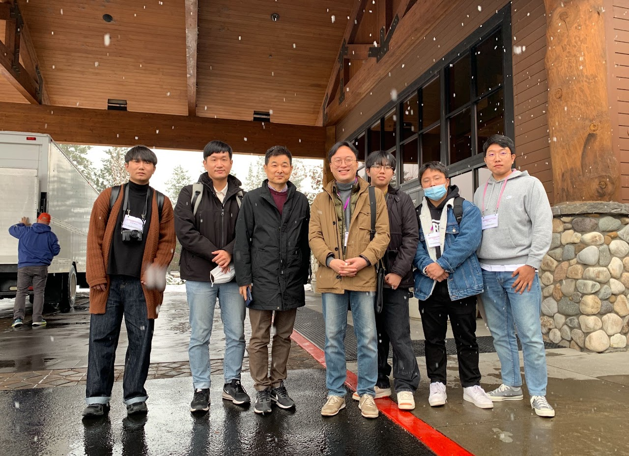 Outdoor group photo during snowfall at UIST 2022.